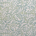 Wallpaper in a botanical paisley print in white on a mottled green and turquoise field.