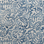 Wallpaper in a botanical paisley print in white on a mottled navy field.