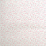 Wallpaper in a minimal floral print in navy and pink on a cream field.