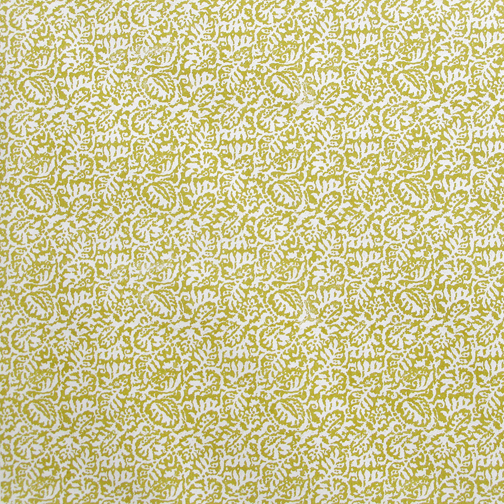 Detail of wallpaper in a dense paisley print in white on a mustard field.
