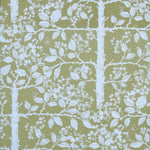 Detail of wallpaper in a large-scale tree and leaf print in white on a light green field.