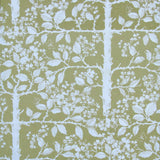 Detail of wallpaper in a large-scale tree and leaf print in white on a light green field.