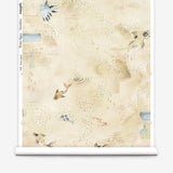 Partially unrolled wallpaper yardage in a playful koi pond print in shades of blue and tan on a yellow field.