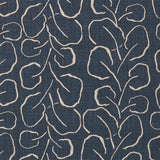 Woven fabric swatch with a large-scale repeating leaf print in tan on a navy blue background.