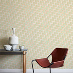 A modernist armchair stands in front of a wall papered in a playful zigzag stripe print in shades of pink, beige and green.