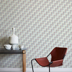 A modernist armchair stands in front of a wall papered in a playful zigzag stripe print in shades of beige, blue and brown.