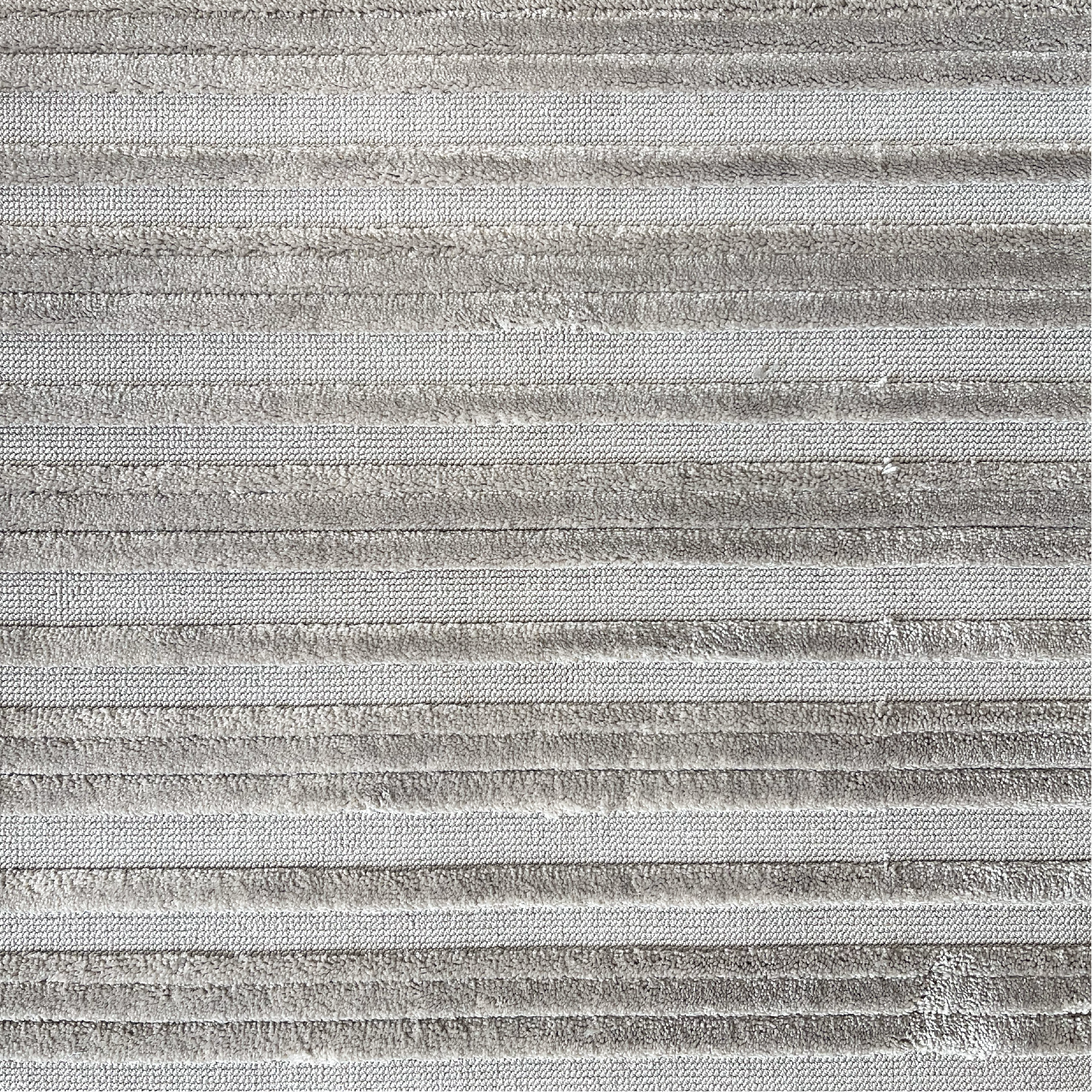 Textured carpet with horizontal loop and raised cut pile stripes in grey.