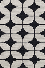 Detail of Alhambra Rug in black and white a featuring a pattern of linked circles that create a star like lattice.