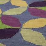 Detail of Alhambra Rug in multi color yellow, green, magenta, purple and blue featuring a pattern of linked circles that create a star like lattice