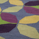 Detail of Alhambra Rug in multi color yellow, green, magenta, purple and blue featuring a pattern of linked circles that create a star like lattice