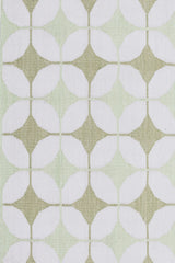 Detail of Alhambra Rug in Olive featuring pattern of linked circles that create a star like lattice in a soft olive and lime green on an ivory field. 