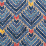 Detail of the Arrow Rug in Indigo-Coral features a dense pattern of nesting arrow shapes in shades of blue with accents of coral and yellow on a light brown field