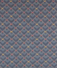 The Arrow Rug in Indigo-Coral features a dense pattern of nesting arrow shapes in shades of blue with accents of coral and yellow on a light brown field