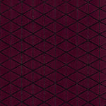 Detail of the Bucky Rug in berry, features a wide black border with a wine colored lattice field with a metallic sheen. 