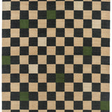 Detail of the Checkerboard Rug in King, a black and tan checkered pattern with random accents of green and white. 