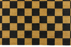 Detail of the Checkerboard Rug in Queen, a black and ochre yellow checkered pattern. 