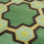 Detail of the Cordoba Cut Pile Rug in Emerald, a hexagonal lattice pattern with sahdes of emerald, jade, yelow and chcolate brown. 