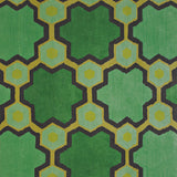 Detail of the Cordoba Cut Pile Rug in Emerald, a hexagonal lattice pattern with sahdes of emerald, jade, yelow and chcolate brown. 