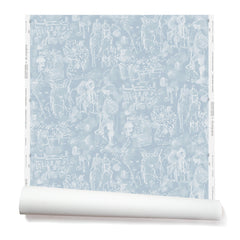 Partially unrolled wallpaper with a pattern of repeating watercolor illustrations of horses, farmers and country houses in white on a blue background.