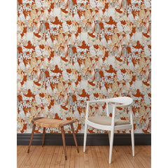 A chair and stool in front of a wall papered in a pattern of many different types of illustrated watercolor dogs with a red background.