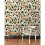 A chair and stool in front of a wall papered in a pattern of many different types of illustrated watercolor dogs with a green background.