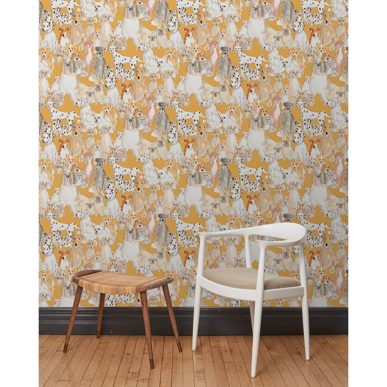 A chair and stool in front of a wall papered in a pattern of many different types of illustrated watercolor dogs with a mustard background.
