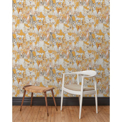 A chair and stool in front of a wall papered in a pattern of many different types of illustrated watercolor dogs with a mustard background.