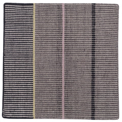 Detail of the Jasper Waffle Rug in Jet, widely spaced thin stripes of yellow, pink, black, acqua and white on a grey field. 