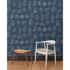 A chair and stool in front of a wall papered in a pattern of white hand-drawn illustrations of New York City landmarks on a navy background.