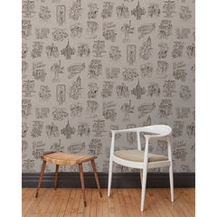 A chair and stool in front of a wall papered in a pattern of black hand-drawn illustrations of New York City landmarks on a tan background.