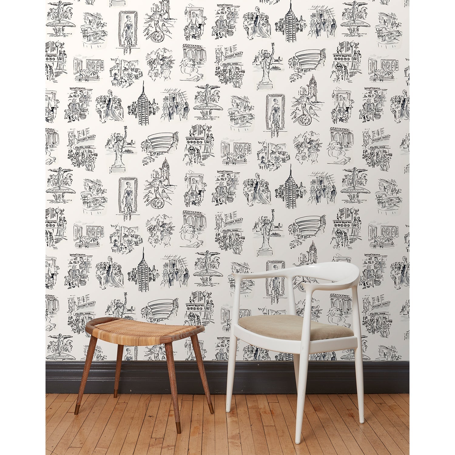 A chair and stool in front of a wall papered in a pattern of black hand-drawn illustrations of New York City landmarks on a white background.