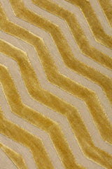 Detail of the Penta Chevron Rug in Lemon Topaz a lemon yellow chevron pattern on a taupe field with a wide solid border. 