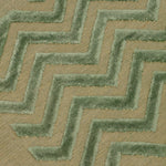 Detail of the Penta Chevron Rug in Pale Jade a light green chevron pattern on a lime green  field with a wide solid border. 