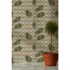 A small round topiary potted plant in front of a wallpaper with a complex two tone olive green stripe floral motif overlayed a white and tan plaid pattern, 