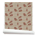 Wallpaper roll with a complex two tone warm pink and soft red floral motif overlayed a white and tan plaid pattern. 
