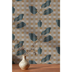A small dried floral branch in an off white vase against a wallpaper with a complex chambray and petrol blue floral motif overlayed a white and tan plaid pattern, 
