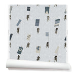 A roll of wallpaper with a pattern of hand-drawn Japanese soldiers carrying various geometric flags, on a light gray background.