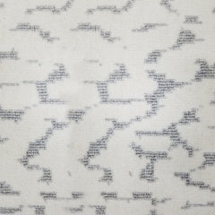 Wool broadloom carpet swatch in a woven cloud pattern in cream with light gray accents.