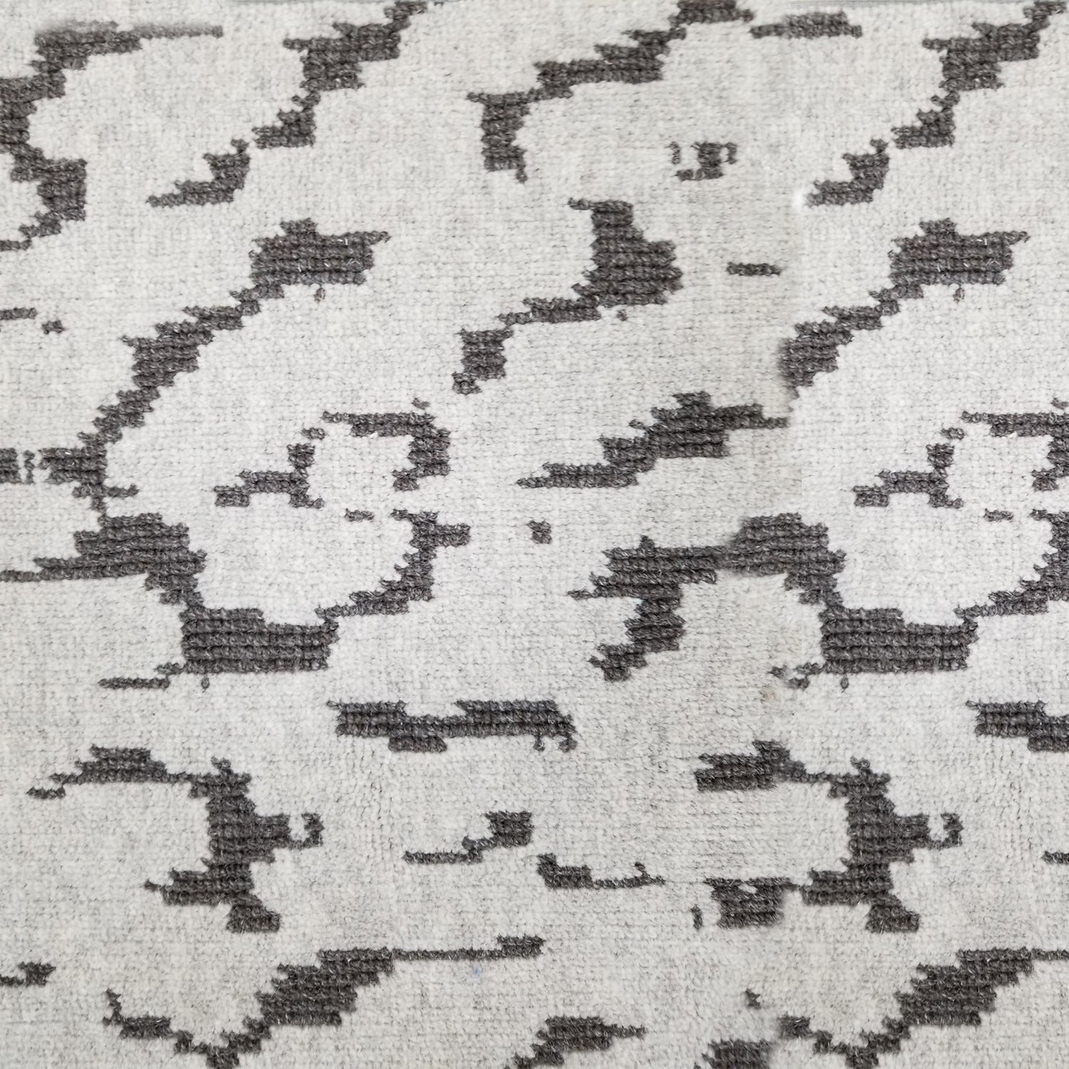 Wool broadloom carpet swatch in a woven cloud pattern in light gray with dark gray accents.