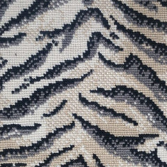 Wool broadloom carpet swatch in a tiger print in gray and black on a mottled cream field.