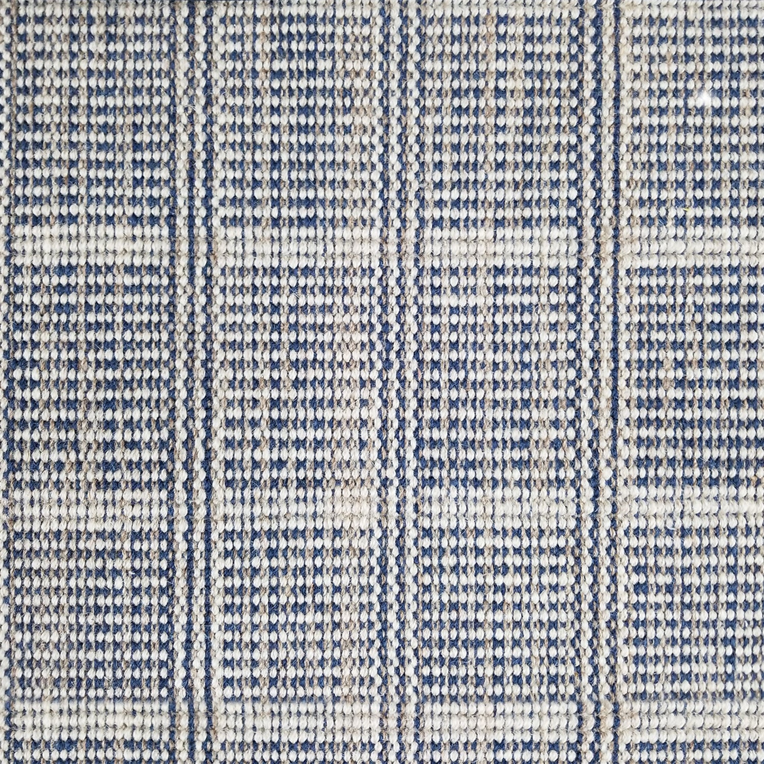 Wool broadloom carpet swatch in a plaid print in shades of navy, tan and cream.