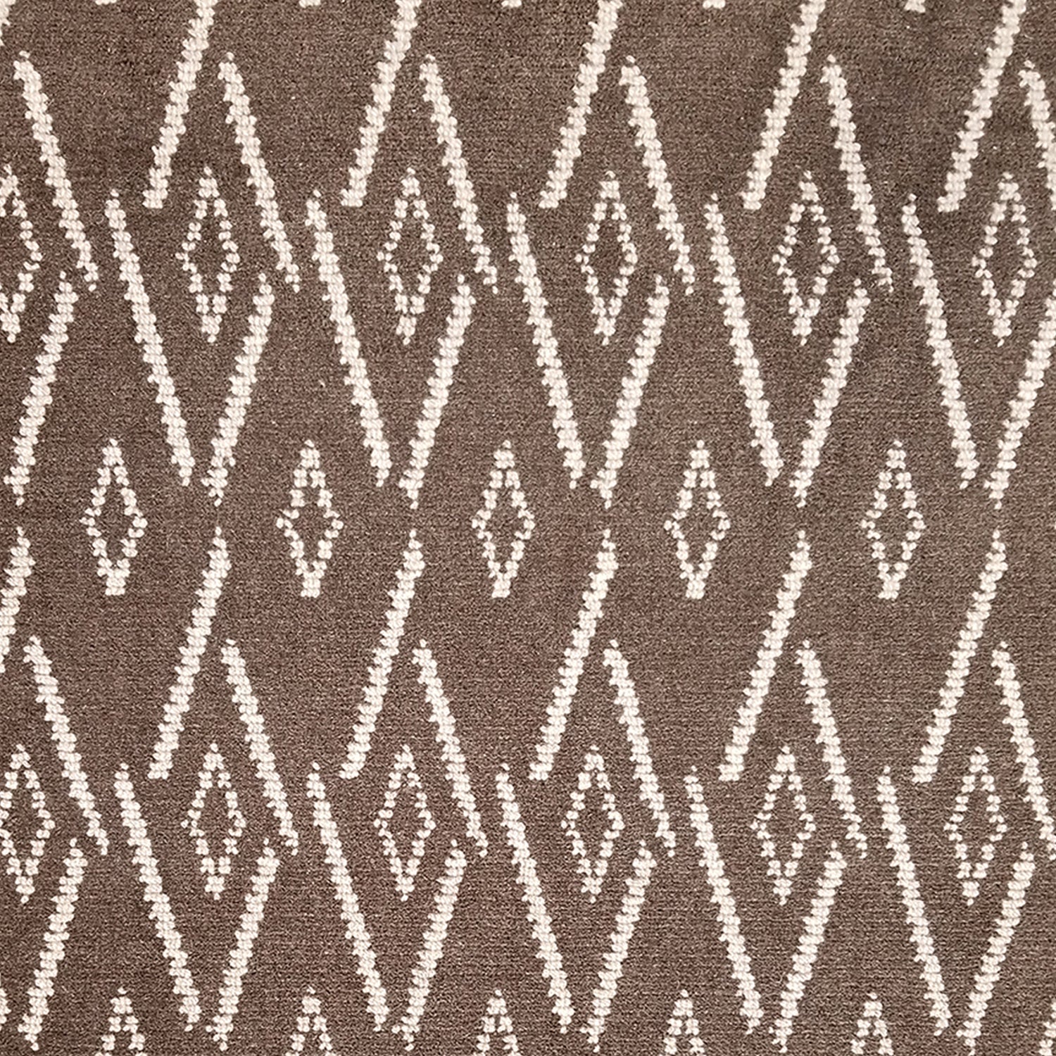 Woven broadloom carpet swatch in a repeating irregular diamond pattern in white on a dark brown field.