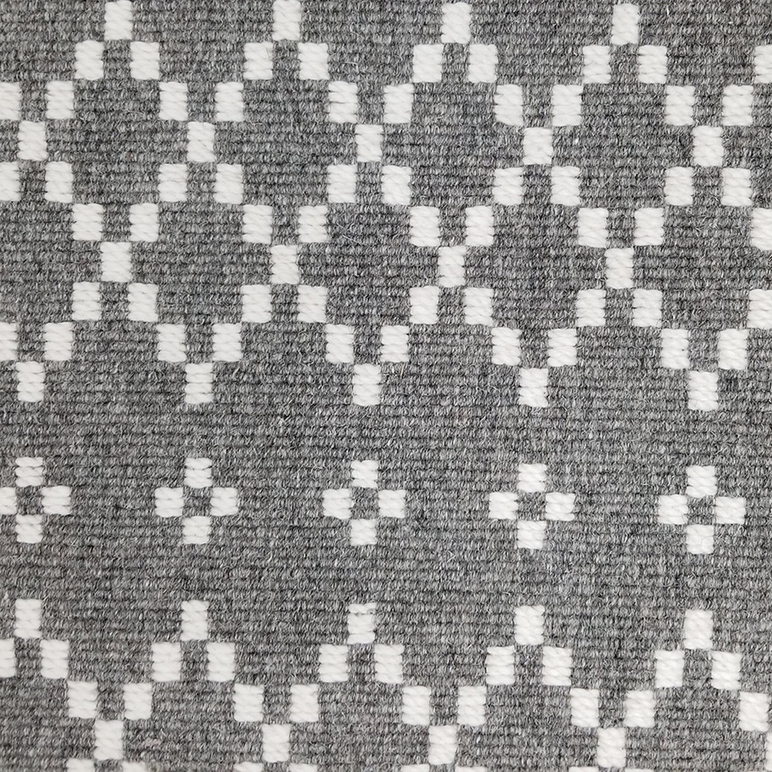 Wool broadloom carpet swatch in a repeating diamond print in white on a gray field.