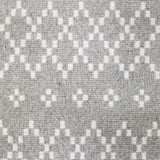 Wool broadloom carpet swatch in a repeating diamond print in white on a light gray field.