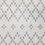 Wool broadloom carpet swatch in a repeating diamond print in light gray on an ivory field.