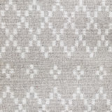 Wool broadloom carpet swatch in a repeating diamond print in cream on a silver field.