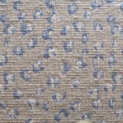 Wool broadloom carpet swatch in a painterly floral pattern in blue and cream on a tan field.