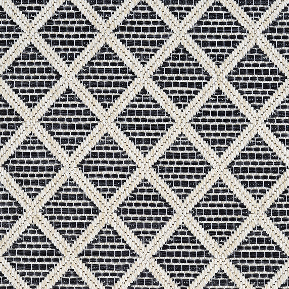 Outdoor broadloom carpet swatch in a geometric diamond weave in beige and charcoal.
