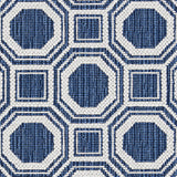Wool broadloom carpet swatch in a repeating geometric grid weave in white and mottled navy blue.