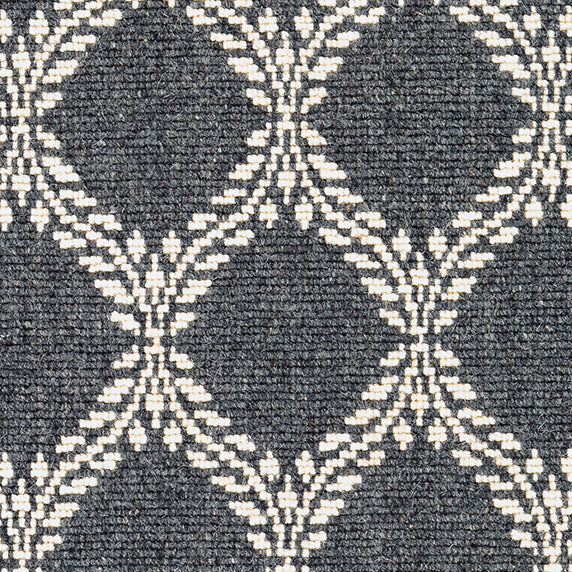 Wool broadloom carpet swatch in a leafy lattice print in white on a charcoal field.